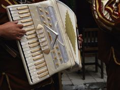 two men in costumes are playing an accordion