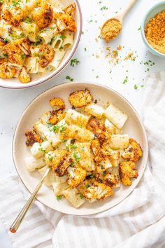 two bowls filled with cauliflower on top of a white table