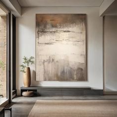 a large abstract painting hangs on the wall in a room with an area rug and two vases