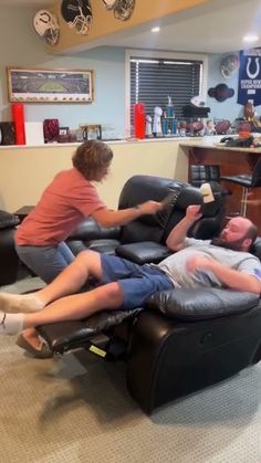 two men sitting on recliners in a living room