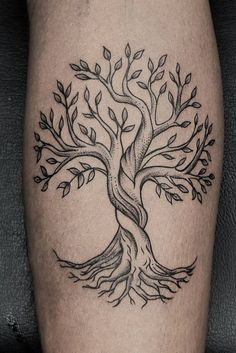 a black and white tree tattoo on the leg