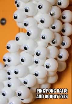 a bunch of white balls with black eyes hanging from the side of a yellow door