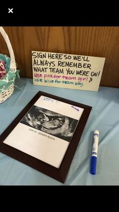 a sign that is on a table next to a basket with flowers and a pen