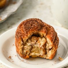 a close up of a doughnut on a plate with a bite taken out of it