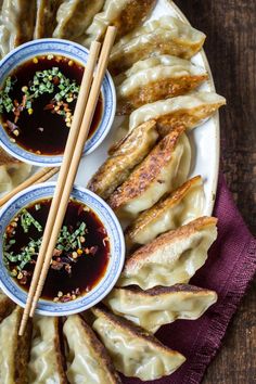 dumplings with dipping sauce and chopsticks on a plate