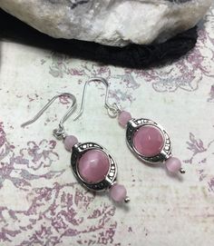 "So Delicate And Pretty These Pink Cats Eye Earrings. Made With, 4mm. Round Matte Pink Cats Eye Stone, 8mm Faceted Round Pink Cats Eye Stones, Antique Silver Plated Ovals, Sterling Silver French Hook Ear Wires And Silver Plated Ball Head Pins. If You Have An Idea For Another Stone Please Let Me Know. Any Item In My Shop Can Be Altered Or Substituted. Cat's Eye acts to stimulate intuition and to enhance awareness. It is a grounding stone that provides a very effective protective energy. Cat's Eye Pink Sterling Silver Earrings For Pierced Ears, Hypoallergenic Pink Round Jewelry, Hypoallergenic Round Pink Jewelry, Pink Hypoallergenic Jewelry, Silver Spiritual Crystal Earrings Nickel Free, Spiritual Nickel-free Pink Jewelry, Silver Nickel-free Spiritual Crystal Earrings, Nickel-free Silver Crystal Earrings For Spiritual Use, Nickel-free Rose Quartz Dangle Earrings