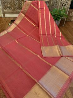 A very unique and stylish pure silk organza benarasi in a super pretty peach-pink shade with horizontal gold stripes. This is a very different benarasi, especially if you are looking to take a break from traditional sarees. The soft gold and peachy pink look stunning together. The horizontal stripes give a modern look to the six yards. The fabric is extremely good quality silk organza. Saree is Silk Mark Certified. What is Kora Silk? Kora silk is untreated or un-dyed silk primarily made out of t Organza Banarasi Saree, Pink Look, Pastel Grey, Jamdani Saree, Pink Shade, Dyed Silk, Banarasi Saree, Organza Saree, Silk Yarn