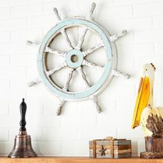 a white ship wheel mounted to the side of a wall next to books and figurines