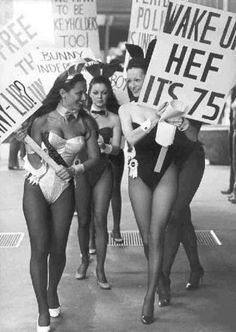 women in bathing suits walking down the street holding signs