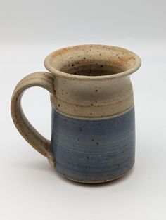 a blue and white coffee mug with brown speckles on the outside, sitting in front of a white background