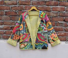 a colorful jacket hanging on a brick wall