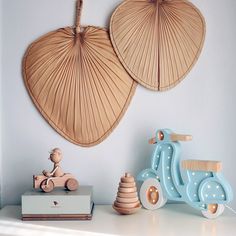 two wooden scooters and a toy motorcycle on a shelf in a child's room