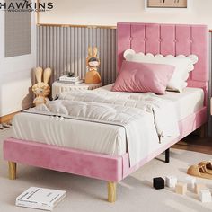 a pink bed with white sheets and pillows on top of it, next to wooden toys