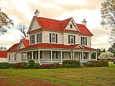 a large white house with red roof and windows