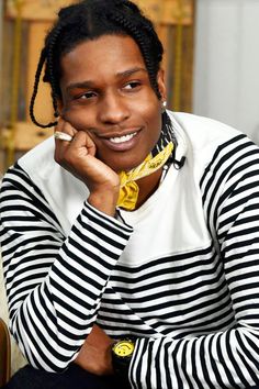 a woman with dreadlocks is smiling and posing for the camera while wearing a black and white striped shirt