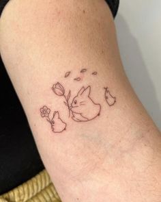 a woman's arm with a tattoo on it that has an image of a rabbit and flowers