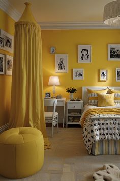 a bedroom decorated in yellow and white with lots of pictures on the wall above the bed