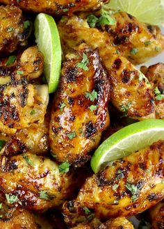 grilled chicken wings with lime wedges and cilantro