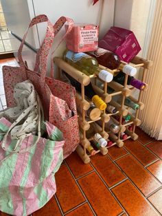 several wine bottles and bags are stacked on the floor