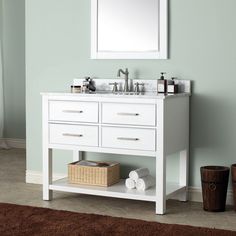 a white bathroom vanity with two sinks and a mirror above it, in front of a blue wall