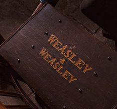 an old wooden chair with the words weasely and weasley on it