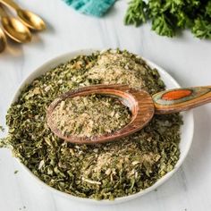 a white bowl filled with herbs next to other items