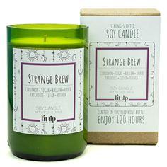 a green candle sitting next to a box on top of a white surface with the words strange brew printed on it