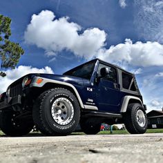 a blue jeep parked on the side of a road