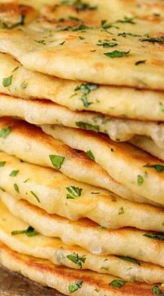 a stack of flat bread with herbs on top