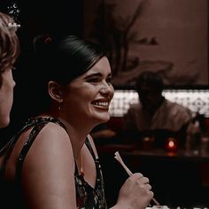 a woman sitting at a table with a plate of food in front of her smiling