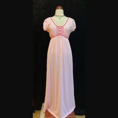 Vintage pastel pink long nightgown.  Shoulder cap sleeves  Magenta trim around neckline and bust.  Three magenta buttons down the bust.  This beauty had two tiny holes on the front in which I put two tiny floral appliqués to cover.  To sweet not to list.  Women's size Large Please ask for measurements if interested.  Thank you. Pink V-neck Nightgown With Lace Trim, Pink Empire Waist Dress, Pink Lace Trim Dresses For Bedtime, Fitted Pink Nightgown For Sleep, Feminine Pink Short Sleeve Nightgown, Pink Short Sleeve Sleepwear With Lace Trim, Vintage Pink V-neck Nightgown, Vintage Pink Sleep Dresses, Pink Fitted V-neck Nightgown