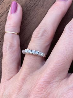 This ring is a great piece for stacking.  It has flat sides which is ideal to go against other stacking rings or traditional engagement rings. There are 2 tapered cut baguette diamonds and 4 round diamonds measuring approx 2mm each for approx .26ctw. H/SI2. Ring weighs 3.0g and measures 3mm at its widest point.  It is not stamped but guaranteed to be 14k white gold. Ring size is 5.25 and sizable. I can size it for an additional charge. Let me know if you need a quote. Platinum Diamond Ring With Baguette Diamonds For Anniversary, Diamond White Emerald-cut Stackable Rings For Anniversary, Emerald Cut Diamond Stackable Rings For Anniversary, 14k White Gold Wedding Ring With Baguette Diamonds, 14k White Gold Baguette Diamond Wedding Jewelry, 14k White Gold Baguette Diamond Wedding Ring, Wedding 14k White Gold Diamond Ring With Baguettes, Classic White Gold Emerald Cut Stackable Rings, Rectangular Platinum Rings For Anniversary