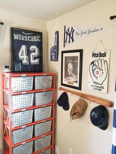 a baseball themed room with many items on the wall and in front of it is a rack full of hats