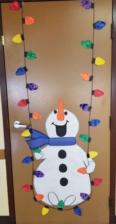 a door decorated with a snowman hanging from the side and lights strung down on it