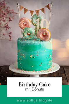 a birthday cake decorated with donuts and sprinkles