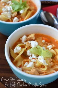 two bowls of chicken noodle soup with feta cheese and cilantro garnish