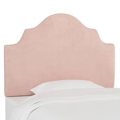 a bed with a pink headboard and white sheets