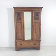 an old wooden armoire with mirrored doors