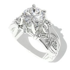 a white gold engagement ring with an intricate design and round brilliant cut diamond in the center