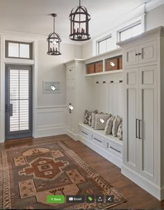 an entryway with built in cabinets and a large rug on the floor next to it