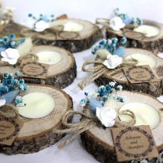 several pieces of wood with some flowers on them and tags attached to the logs that hold candles