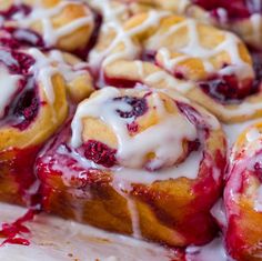 the pastry is covered with white icing and cranberry sauce