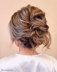 the back of a woman's head, with her hair in a low bun