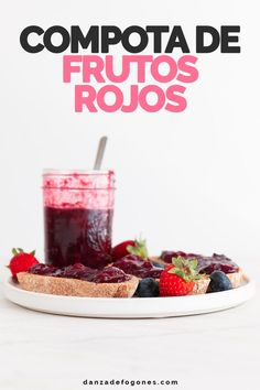 berry compote on a plate next to a glass of juice