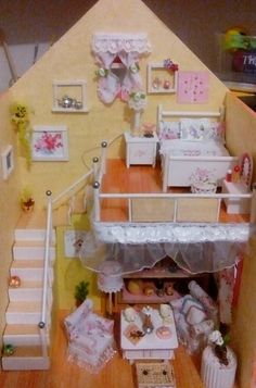 a doll house with furniture and accessories on the floor, stairs leading up to it