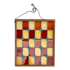 an old stained glass window hanging on a chain