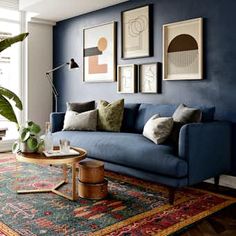 a living room with blue walls and rug on the floor, couch in front of window