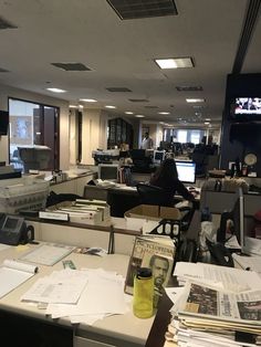 an office filled with lots of desks covered in papers and folders on top of them