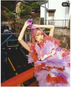 a woman with pink hair and purple gloves