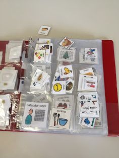 many different types of cards and magnets on a red tray with clear plastic bags